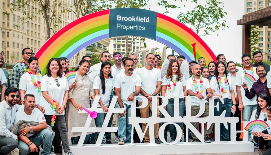 Group of people celebrating Pride Month at Downtown Powai, standing under a rainbow arch with a #PrideMonth sign